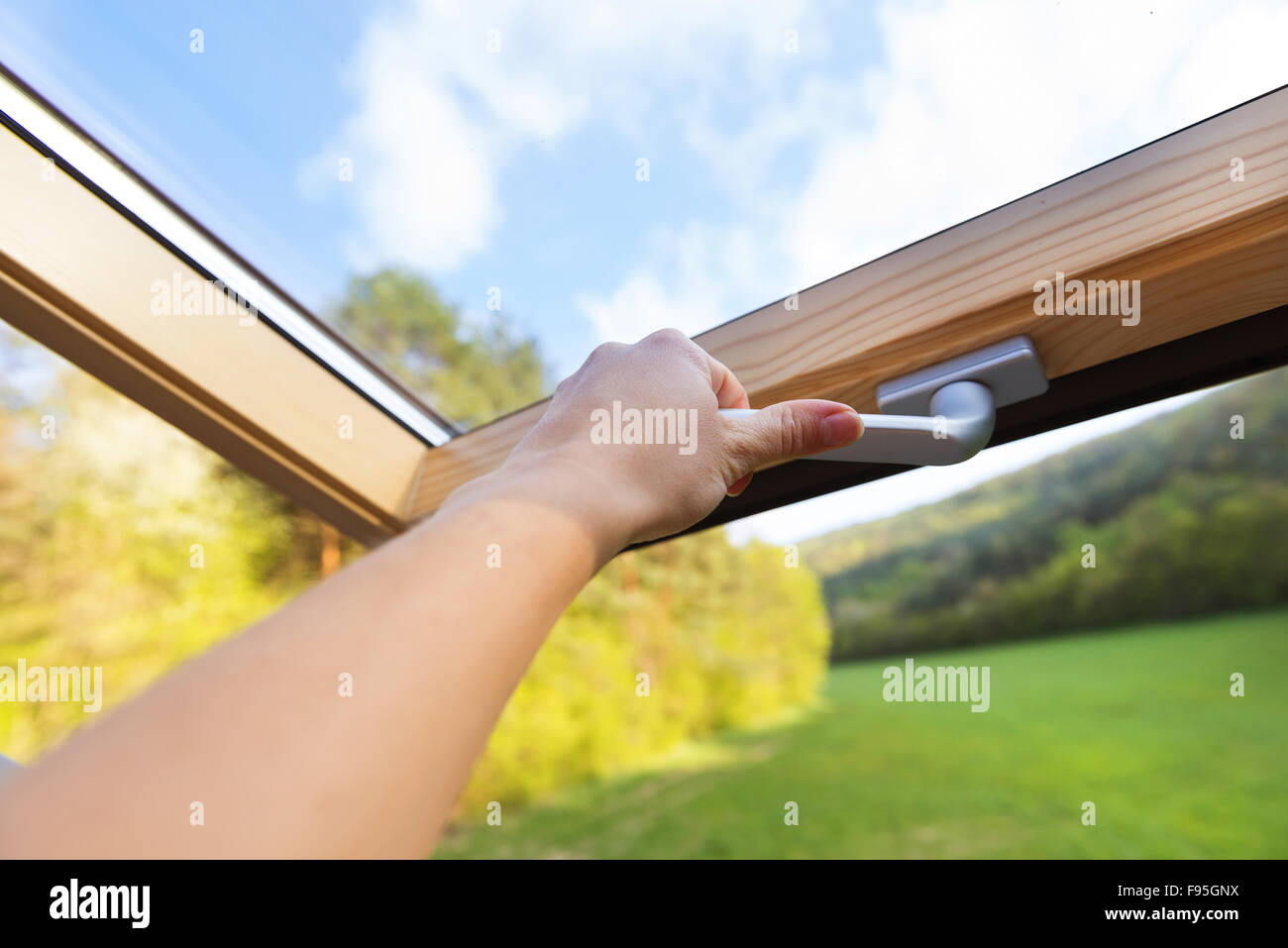 Beautiful nature view through roof skylight window in attic room. Stock Photo