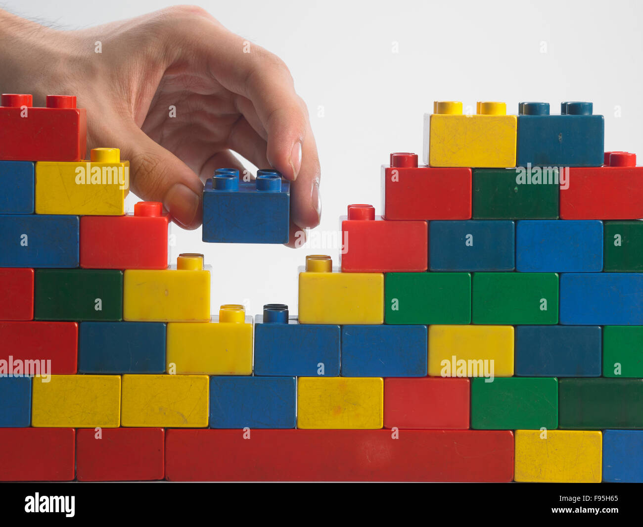 hand stack up lego set as a wall on white background Stock Photo Alamy