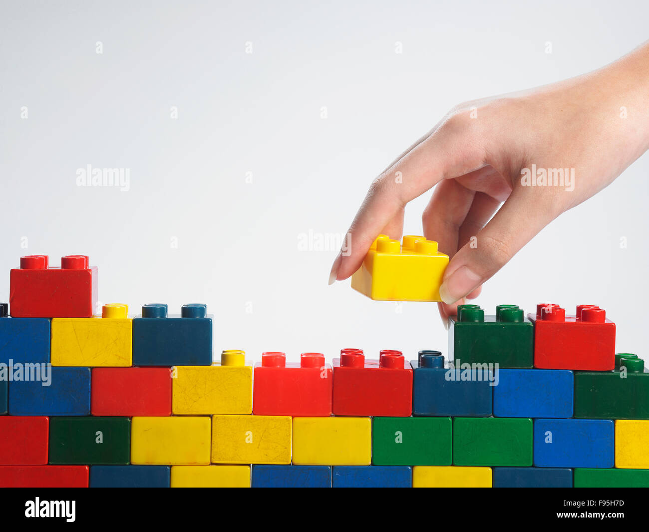 hand stack up lego set as a wall on white background Stock Photo Alamy