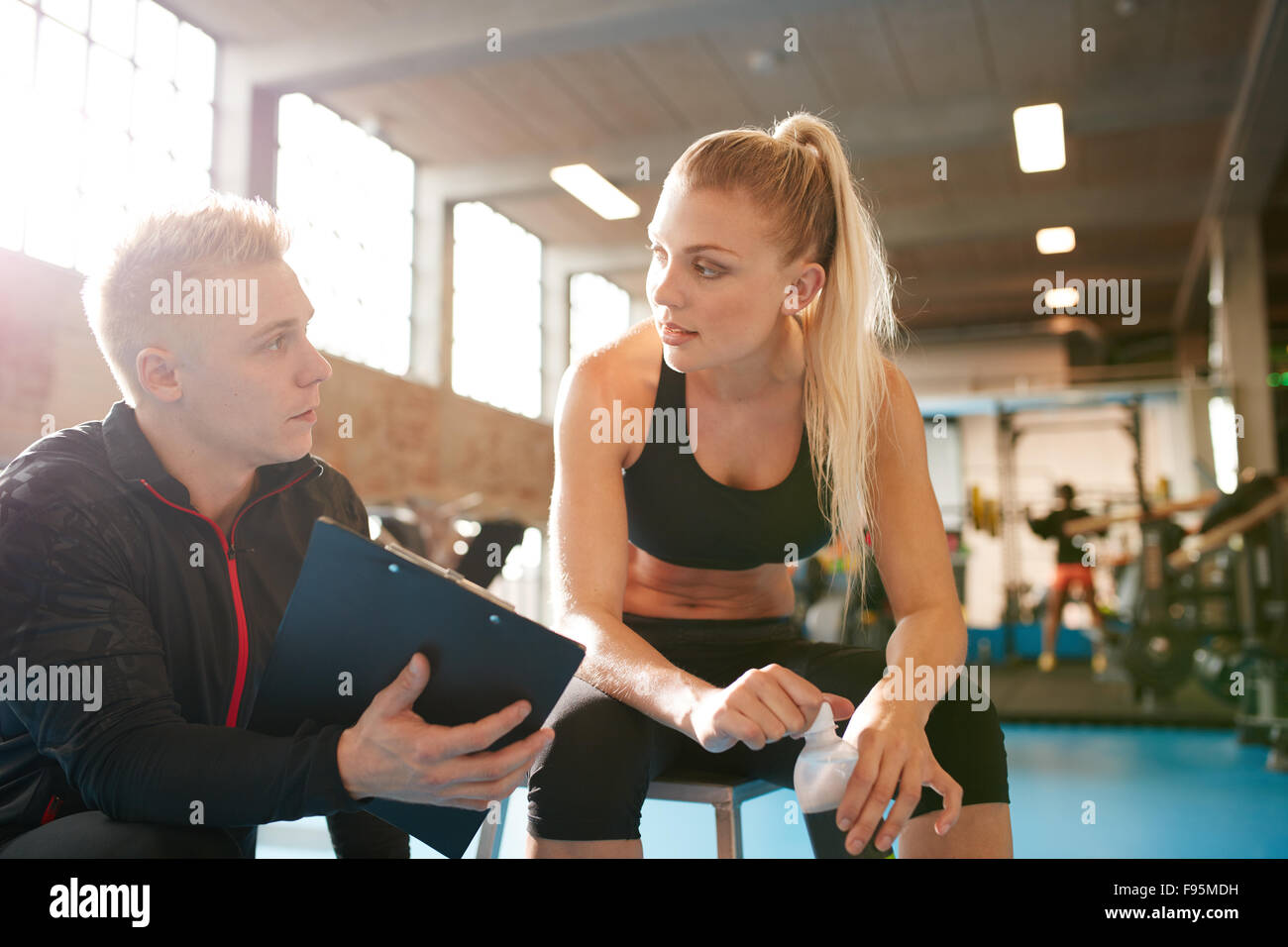 Shot of a personal trainer and young woman discussing fitness plan ...