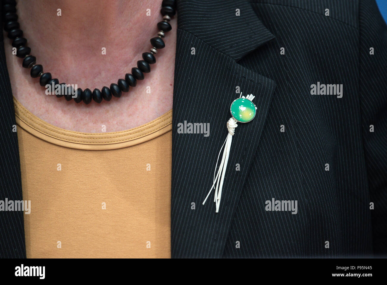 German Environmental Minister Barbara Hendricks speaks about the results of the UN Climate Change Conference in Paris at a press conference in Berlin, Germany, 14 December 2015. She wears a pin on her jacket - a good luck charm made of dried blades of grass - that was distributed in Paris by Tony Brum, Foreign Minister from the Marshall Islands, which will sink if ocean levels continue to rise. After two weeks of negotiations, almost every state in the world settled on a historic climate protection agreement, the main goal of which is to hold the global warming caused by greenhouse gases to we Stock Photo