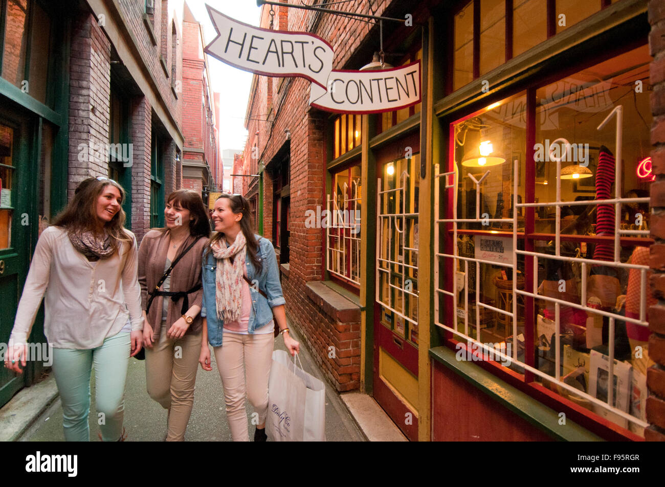 Young women are amazed at the narrow corridor of Fan Tan Alley, an area in Chinatown that features interesting shops in Stock Photo