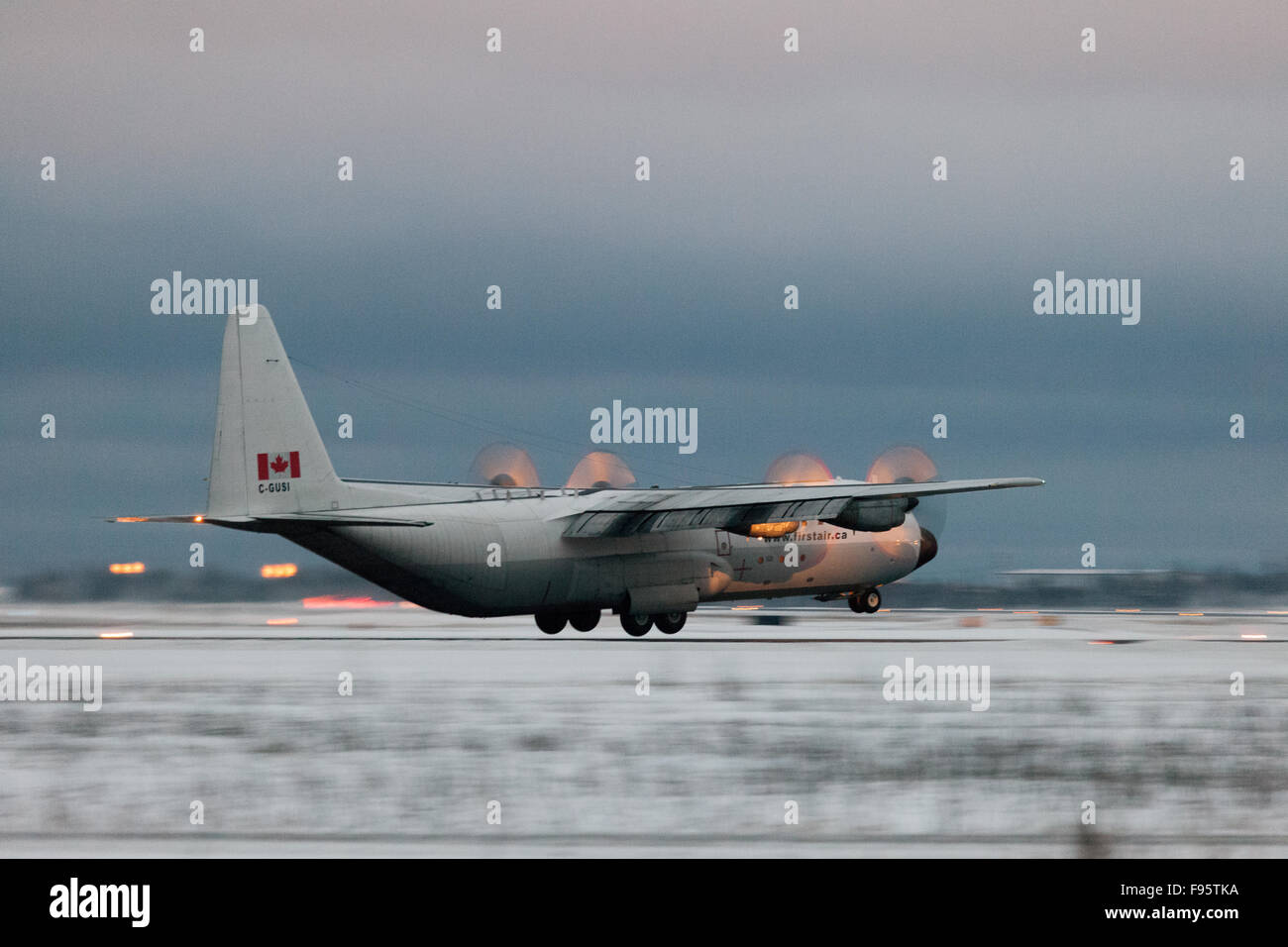 A First Air Hercules cargo plane lands at dusk in Yellowknife, Northwest Territories, Canada Stock Photo