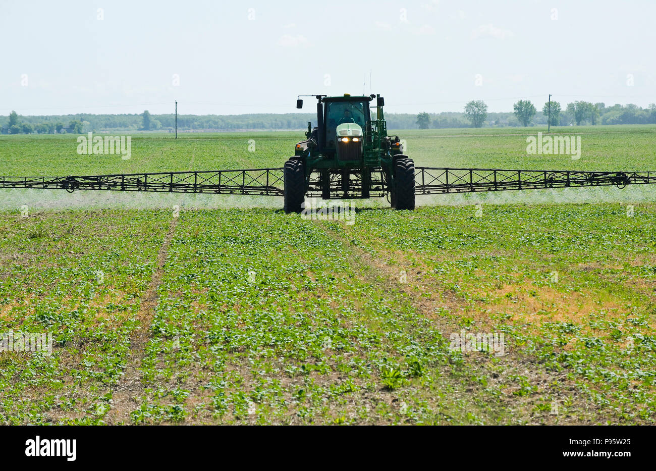 a high clearance sprayer gives a chemical application of herbicide to
