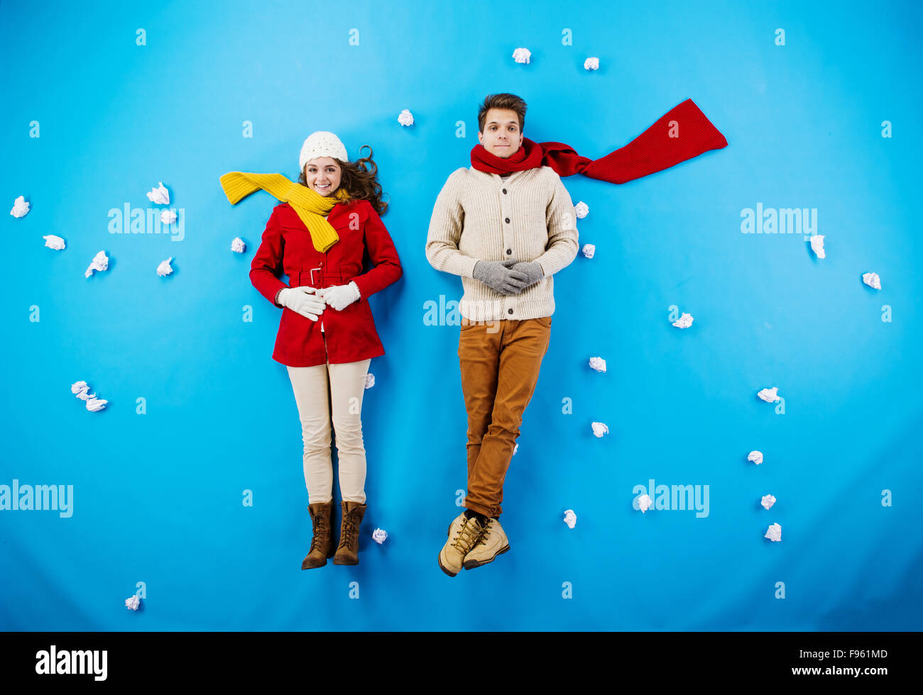 Young couple in winter clothes on blue background Stock Photo