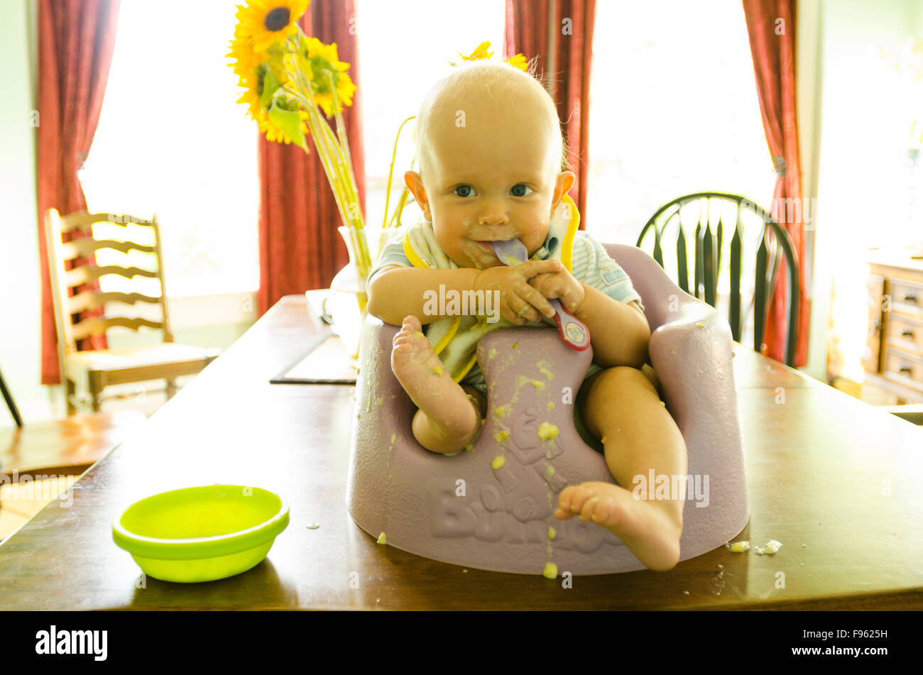 A devilishly cute baby shows the aftermath of a bowl of corn chowder Stock Photo