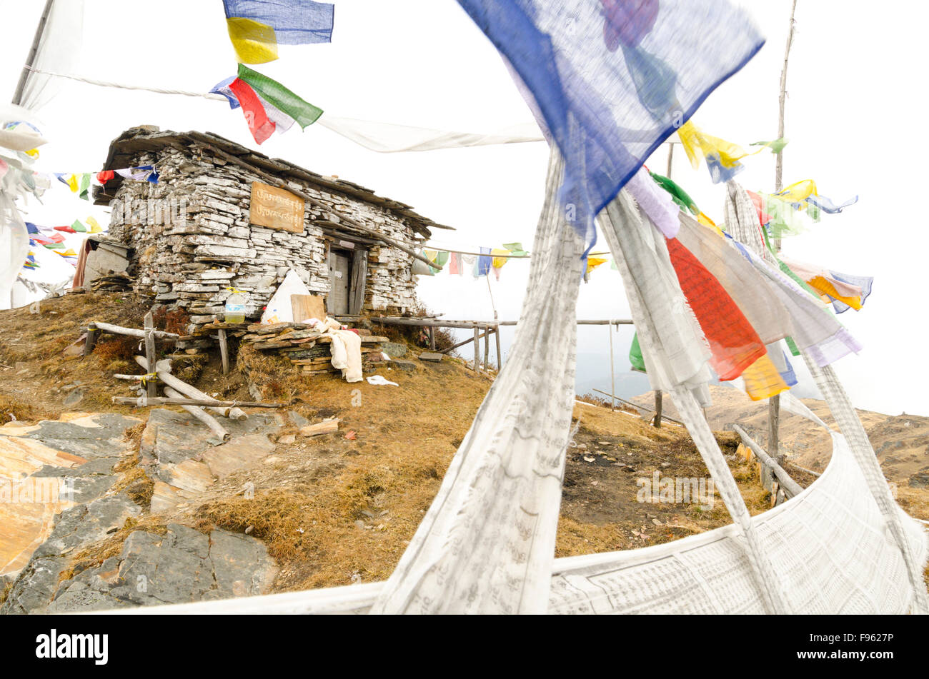 A sky burial monument showing prayer flags and the rack for tying down a human corpse, Bhutan Stock Photo