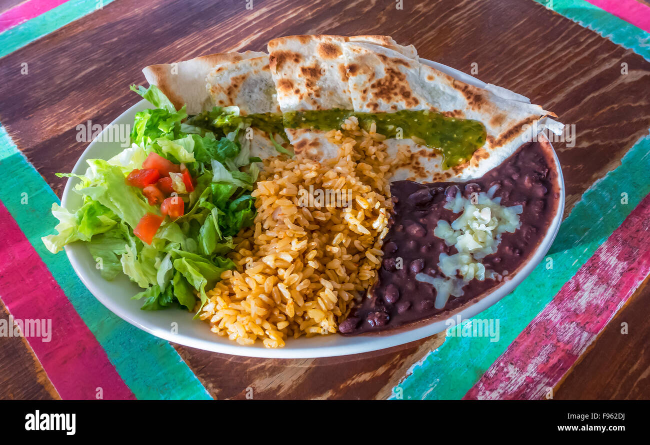Mexican quesadillas with black beans, brown rice, and salad on an old
