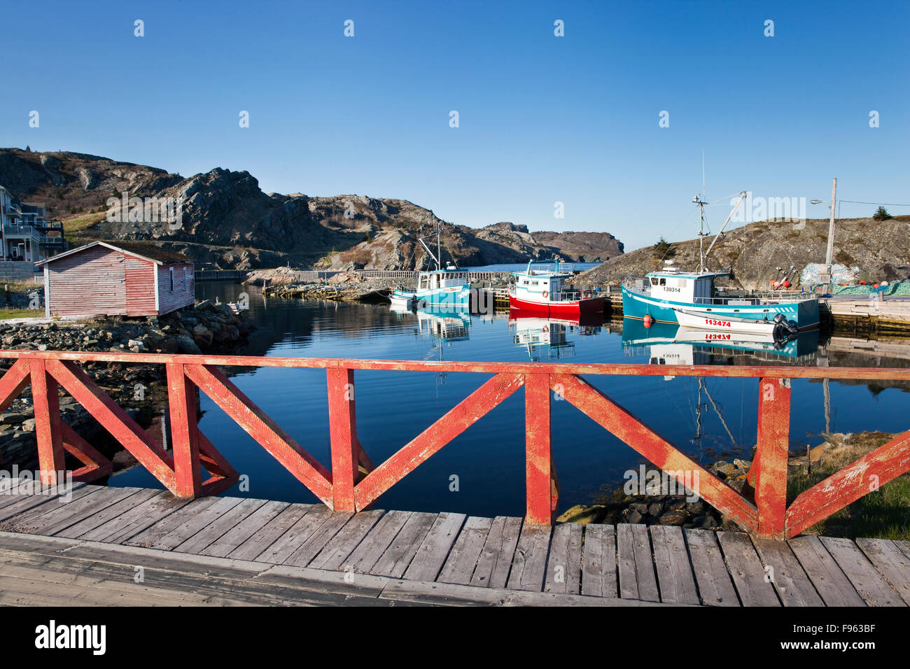 Small harbour and three Cape Islander fishing boats as seen from a bridge on Middle Ridge Rd. in Brigus, Newfoundland, Canada Stock Photo