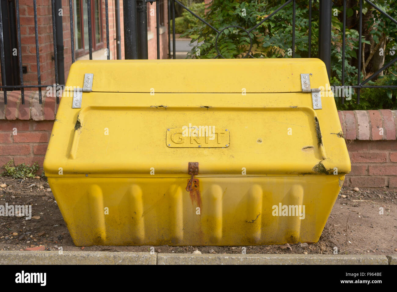 Yellow plastic grit box full ready for bad winter road conditions Stock