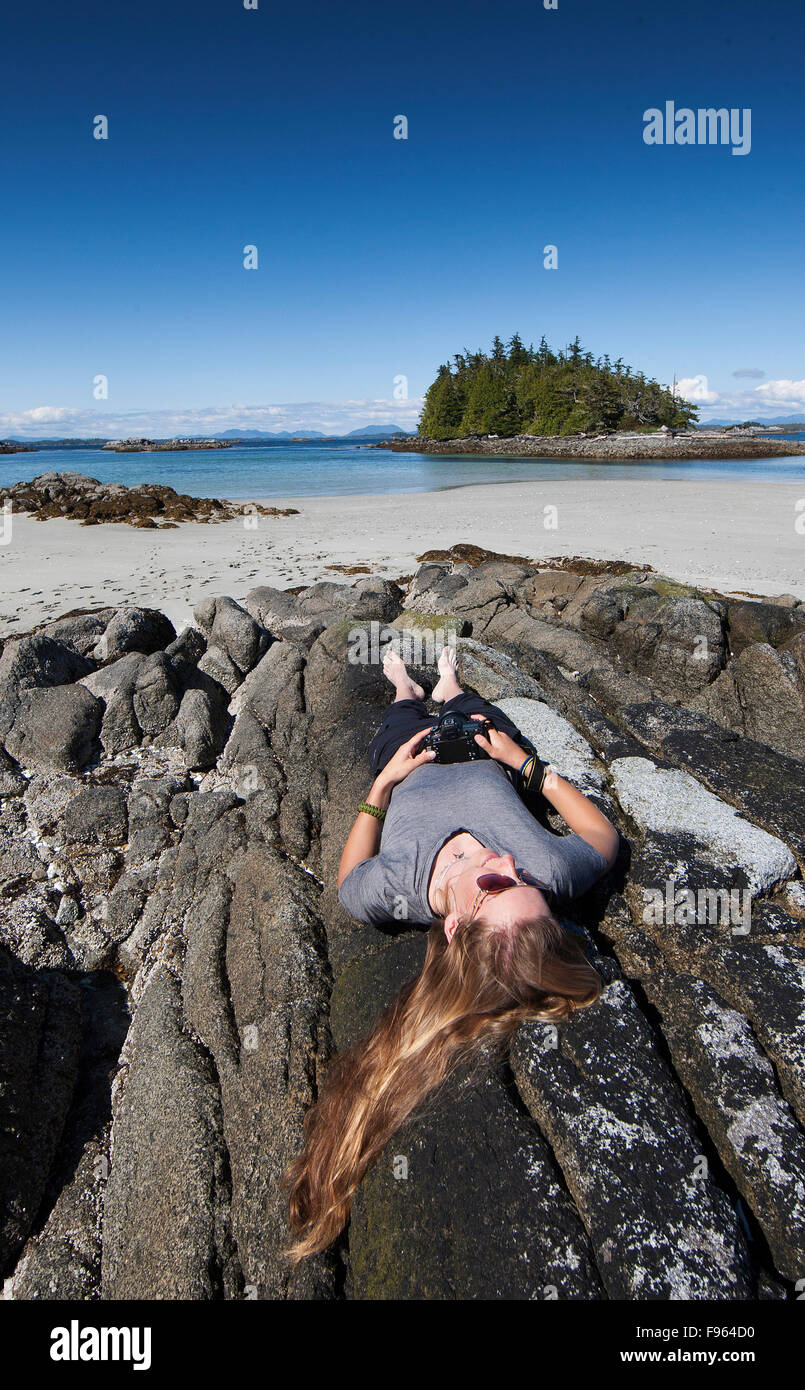A young female photographer photographs a west coast scenic while exploring at the Mcmullin group of Islets.  The great bear Stock Photo
