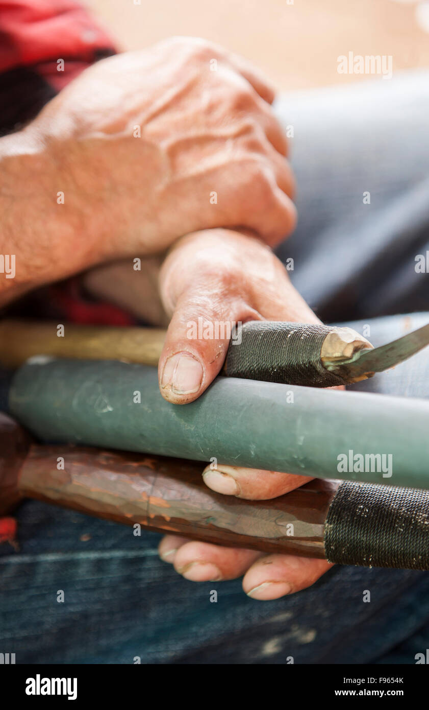A first nations carvers hands tell the tale of countless hours working with wood and the tools of his trade. Stock Photo