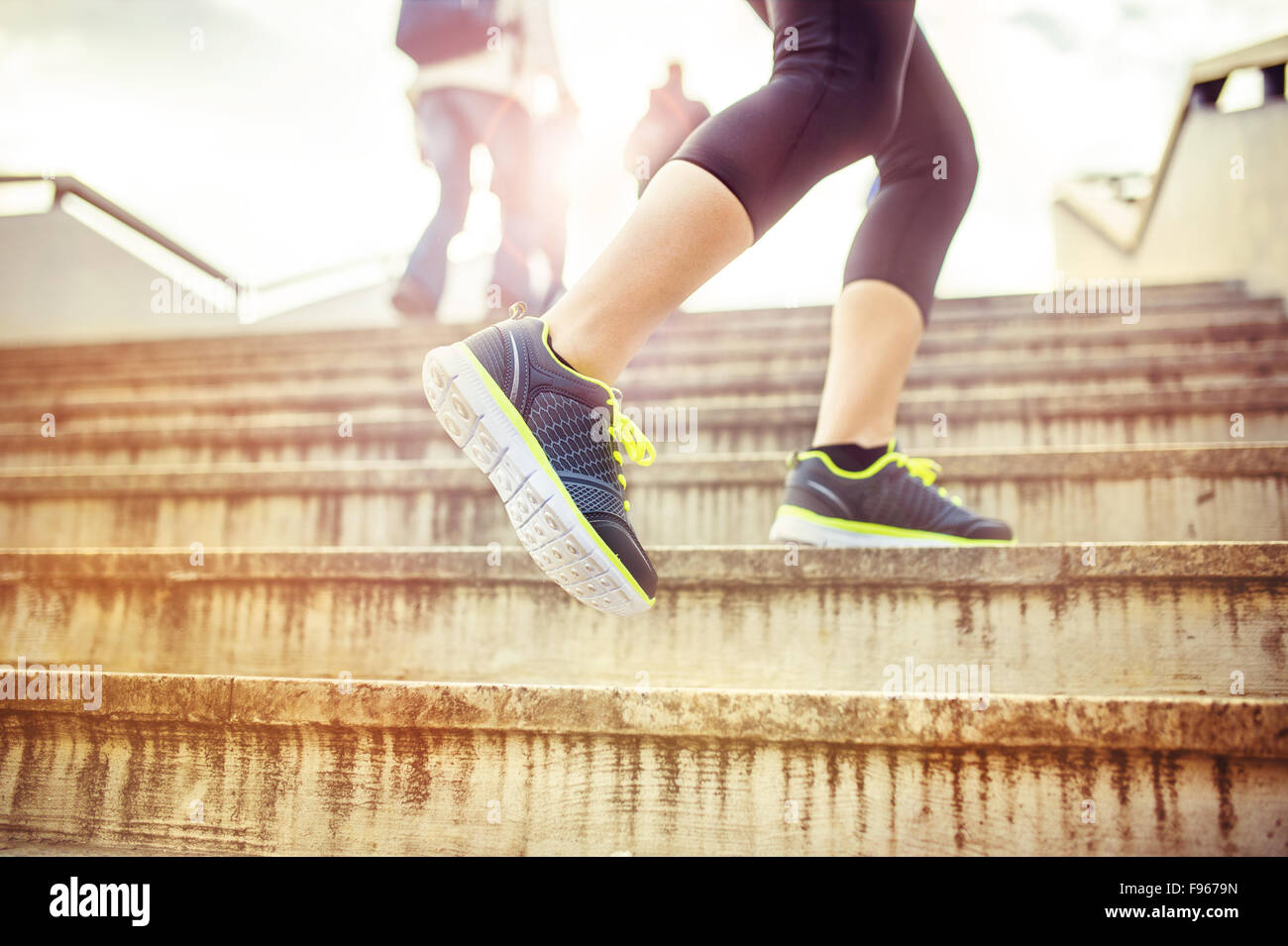 Female runner running up the stairs in city center, closeup on shoes Stock Photo