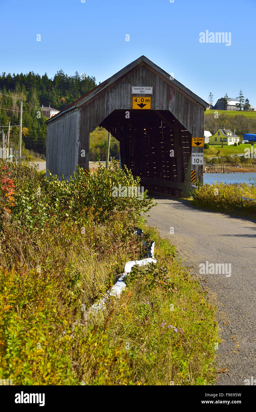 A vertical image of the one lane covered bridge at Tynmouth New Brunswick Canada taken on a clear autumn day. Stock Photo