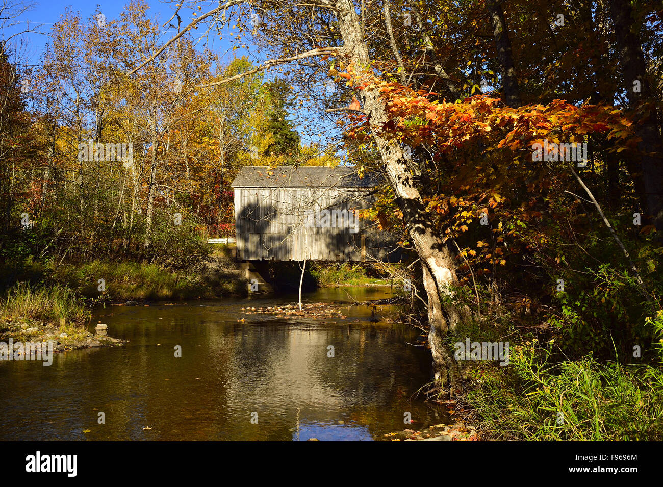 A side view of the iconic wooden covered bridge spanning the Trout Creek at Moors Mills near Waterford New Brunswick Canada Stock Photo