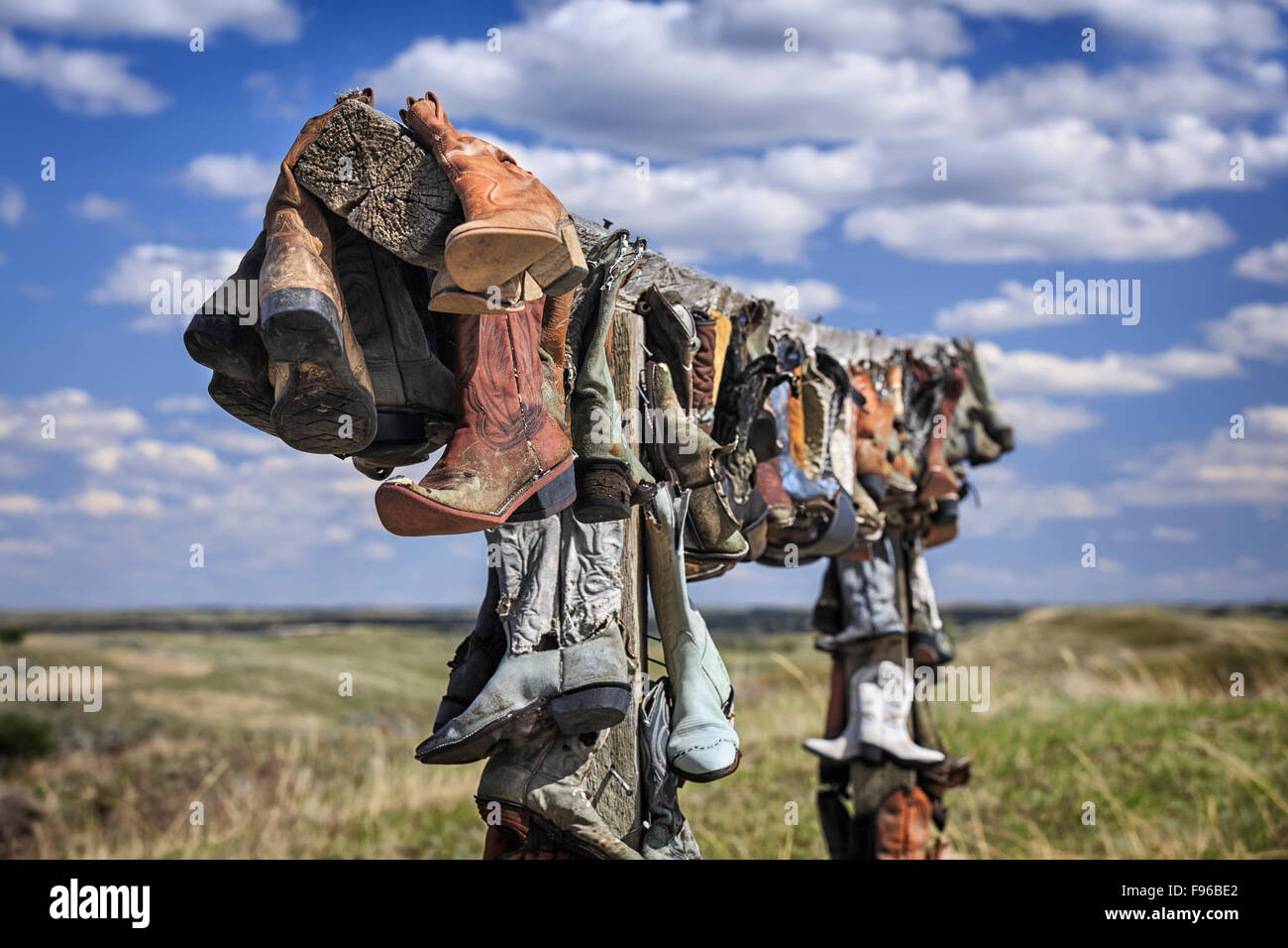 Old cowboy boots hanging in memory of John Booth, Great Sandhills, near Sceptre, Saskatchewan, Canada Stock Photo