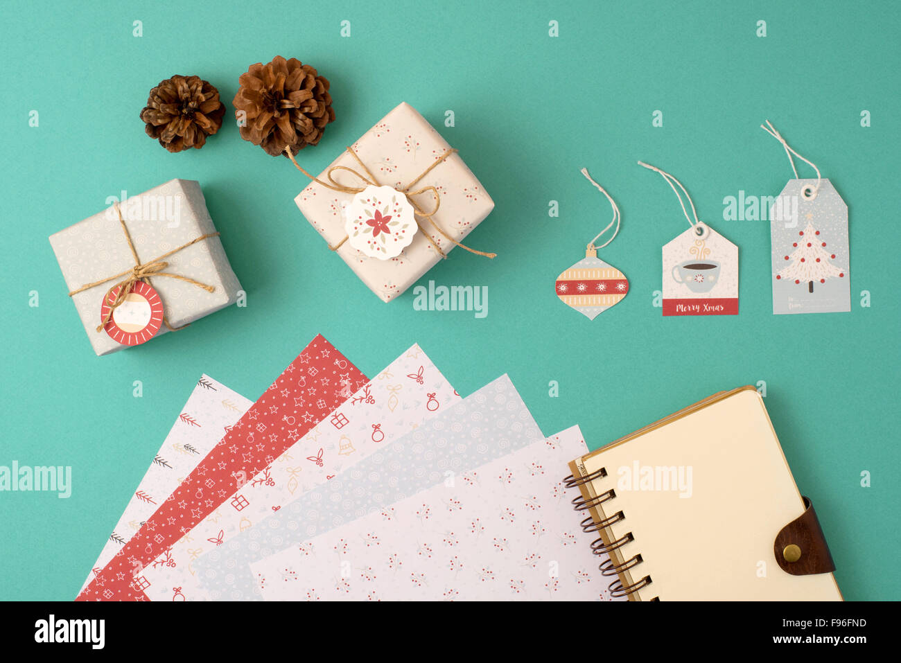 Christmas stationery arrangement top view elements template. Empty spiral notebook with wrapping paper stack, vintage gift boxes Stock Photo
