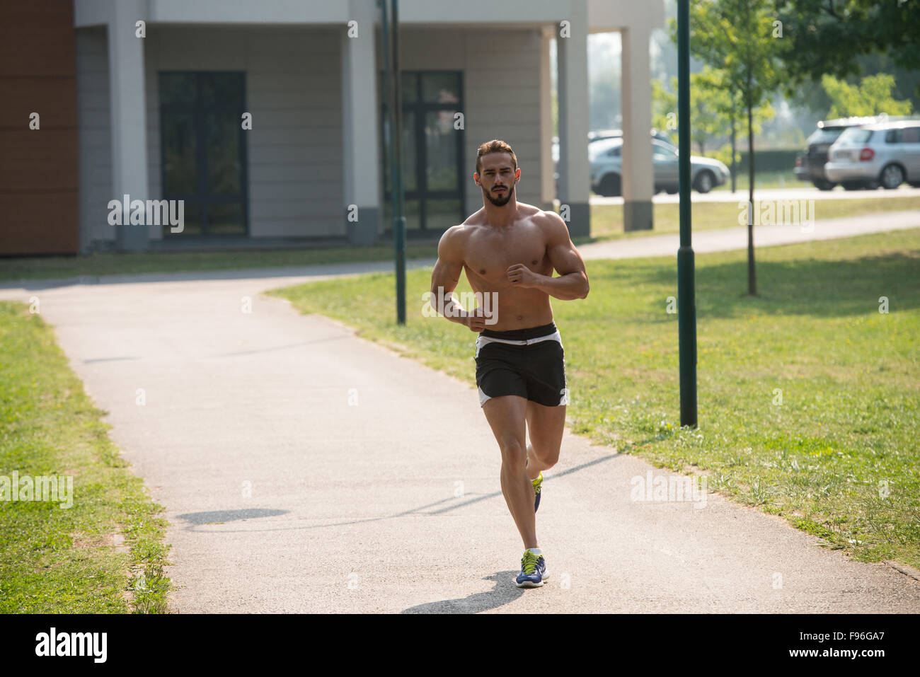 Young Bodybuilder Running In Park Area Training And Exercising For
