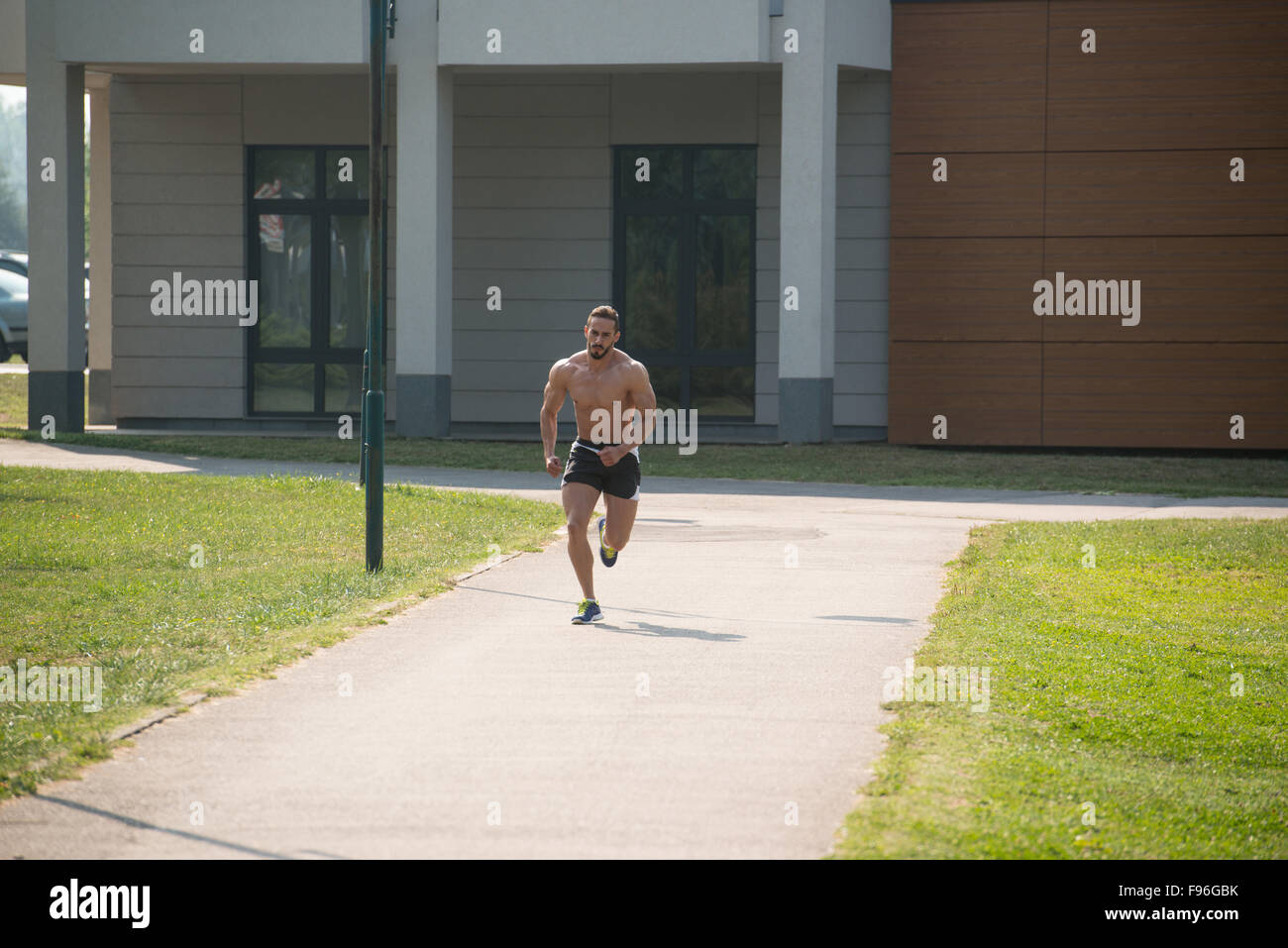 Young Bodybuilder Running In Park Area Training And Exercising For