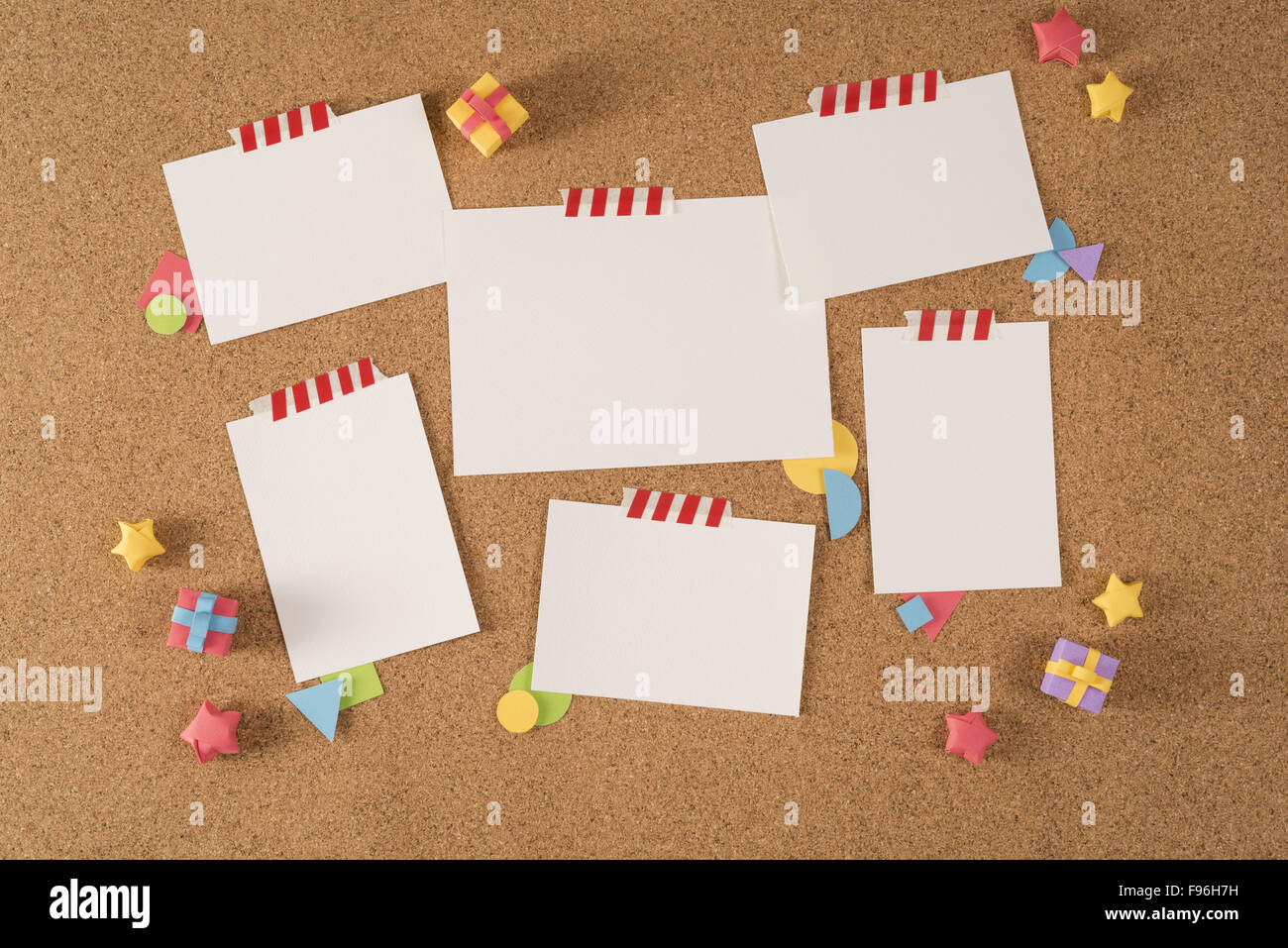 Set of blank paper template notes taped on cork notice board with