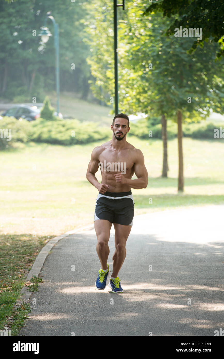 Young Bodybuilder Running In Park Area Training And Exercising For