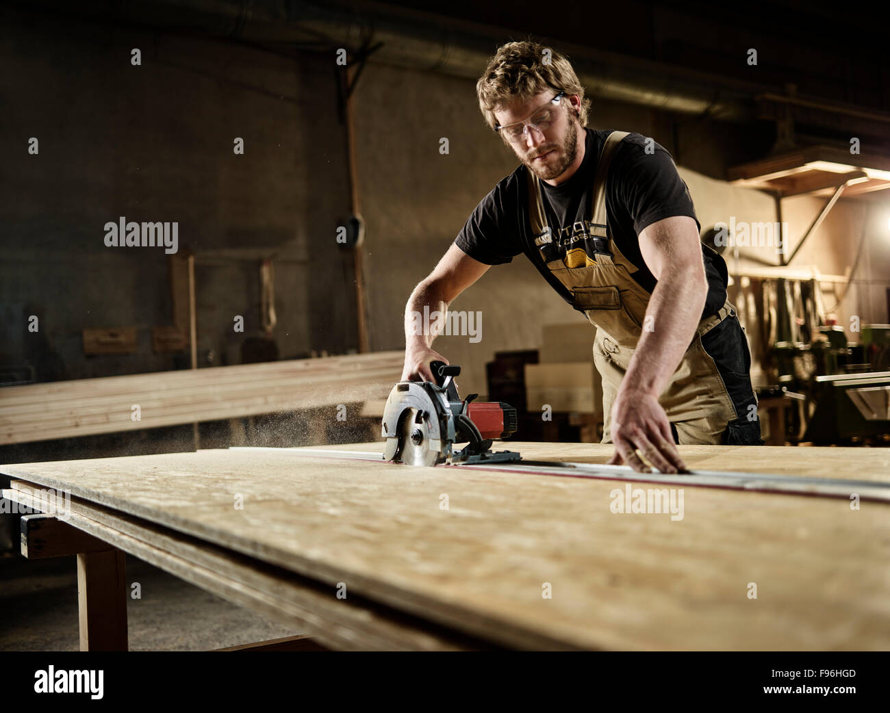 Carpenter cutting chipboard with a circular saw, Austria Stock Photo