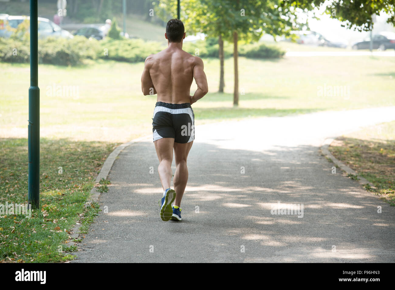 Young Bodybuilder Running In Park Area Training And Exercising For
