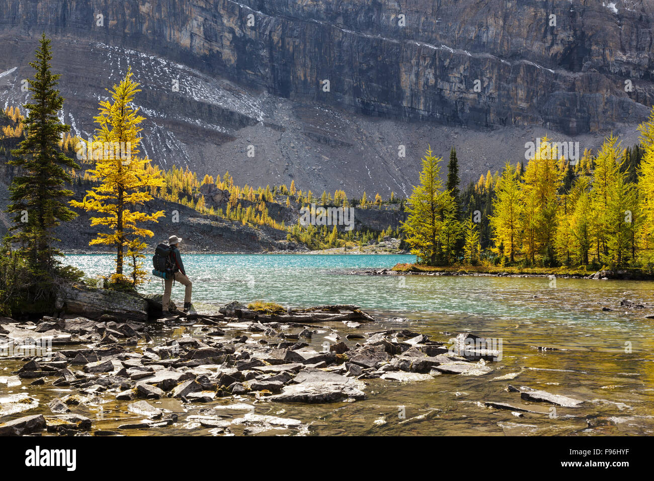 A back packer pauses on the shore of Skoki Lake in the Skoki wilderness area of Banff National Park, Alberta, Canada. Model Stock Photo