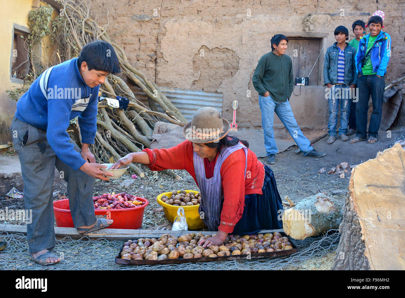 Schoolboy and cook preparing potatoes at a boarding school for breakfast, on an open fire, boarding in Potosi, Bolivia Stock Photo