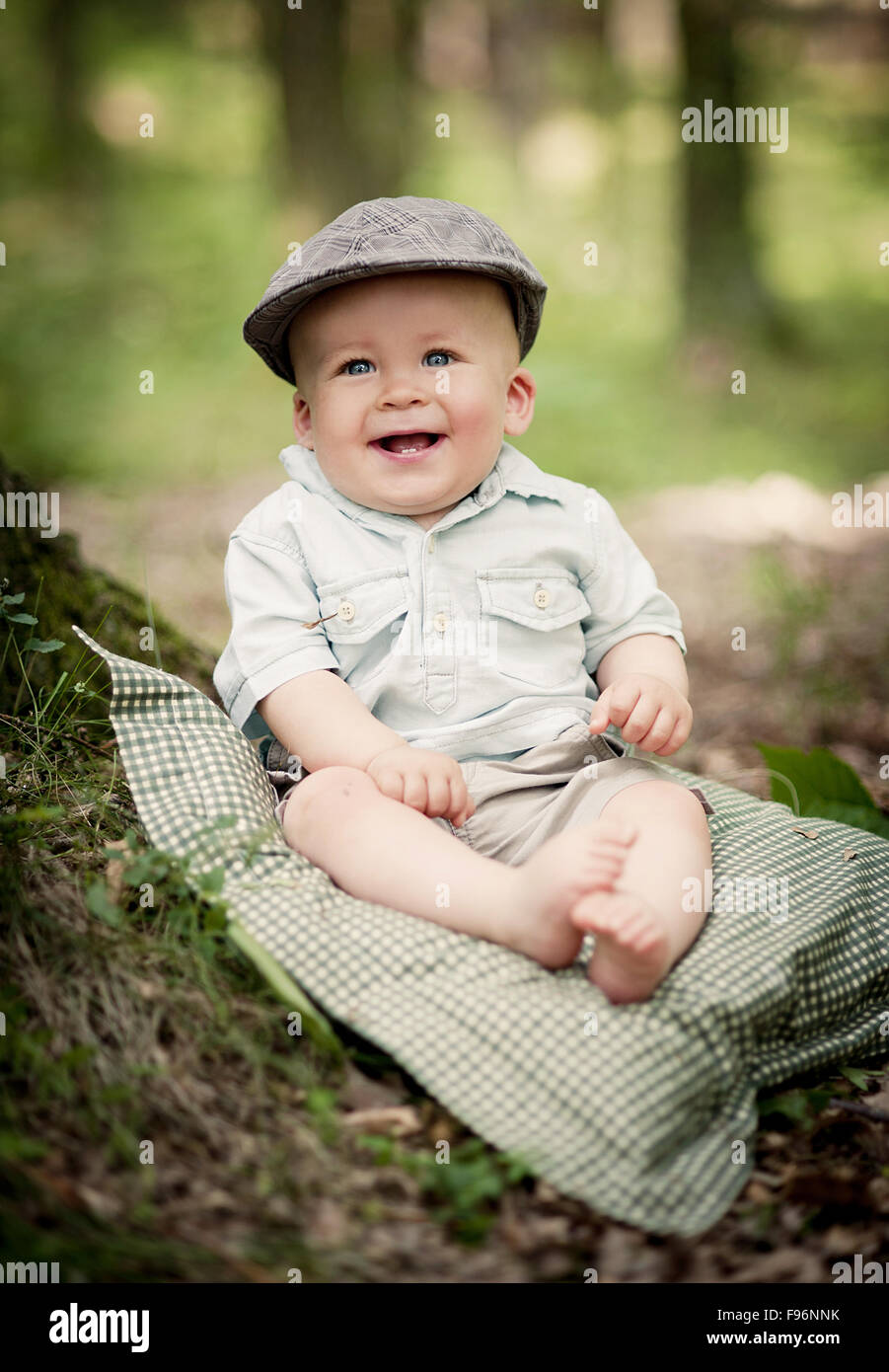 Portrait of cute smiling baby boy sitting in the forest Stock Photo - Alamy