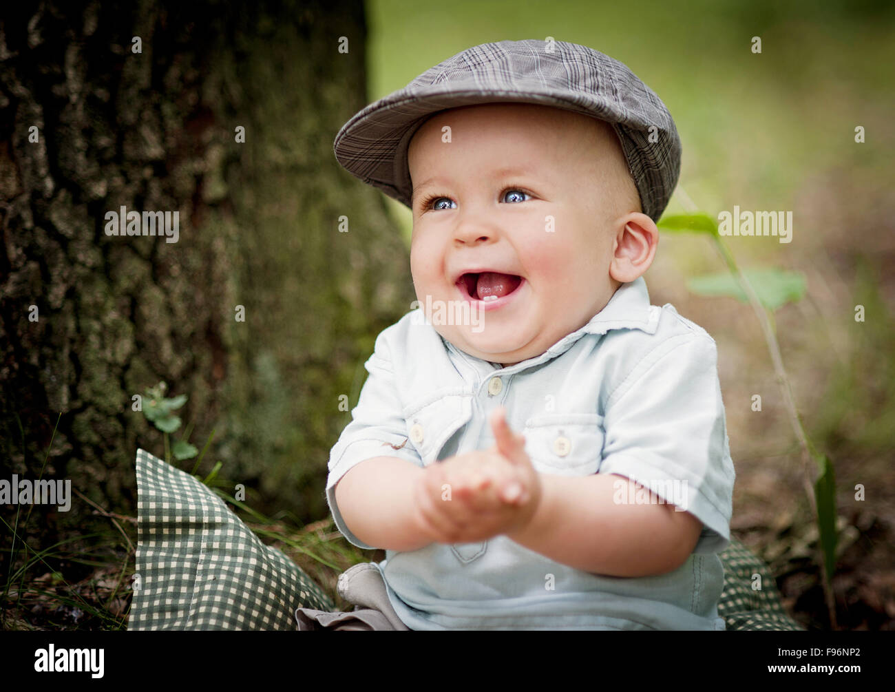 Portrait of cute smiling baby boy sitting in the forest Stock Photo - Alamy