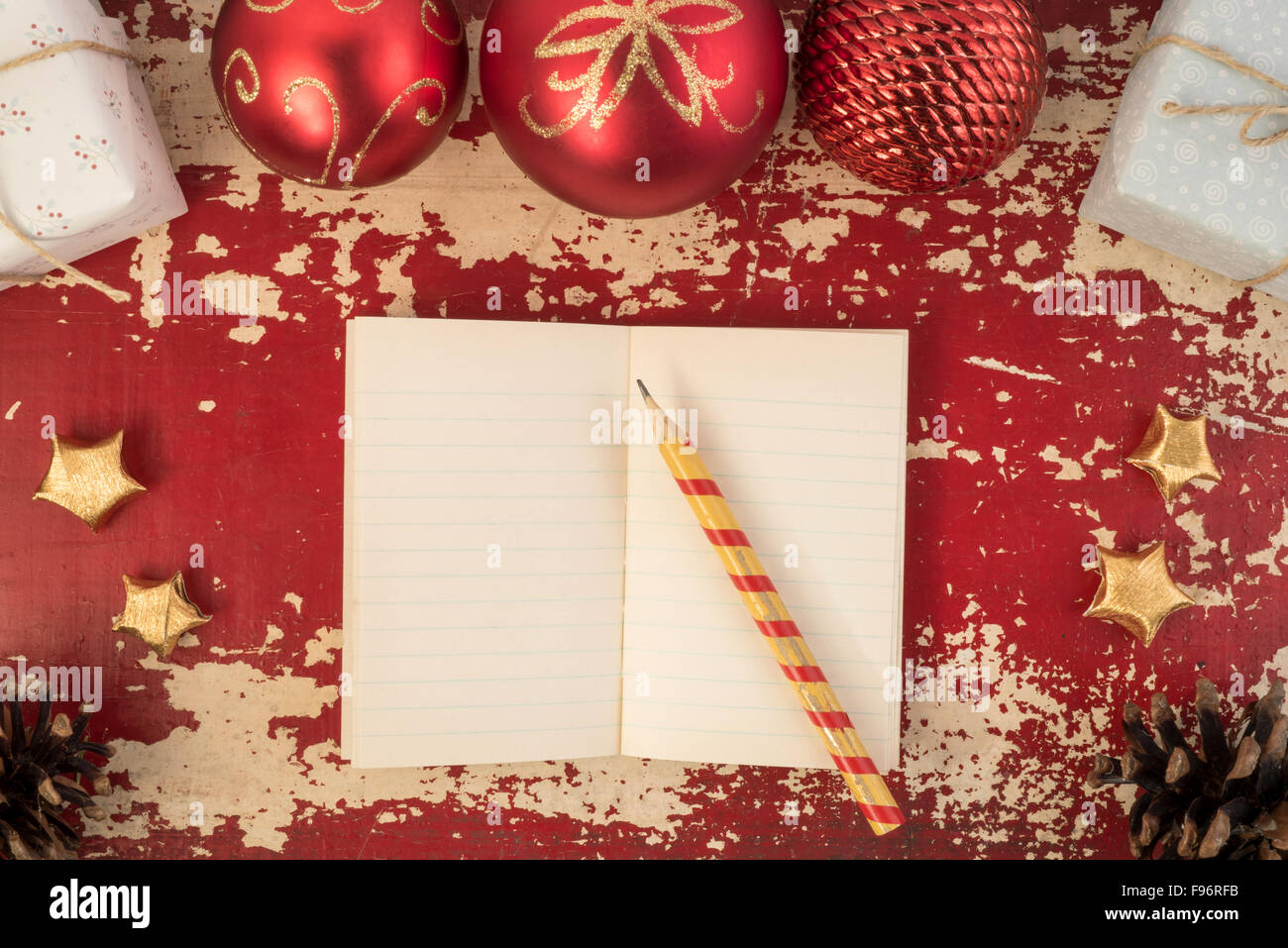 Christmas card background, top view notebook template with pencil and vintage holiday decoration ornaments on grunge wood Stock Photo