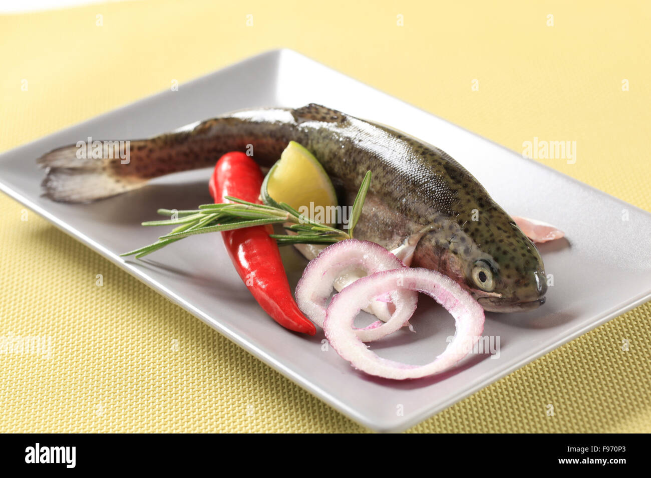 Fresh trout and other ingredients on a plate Stock Photo
