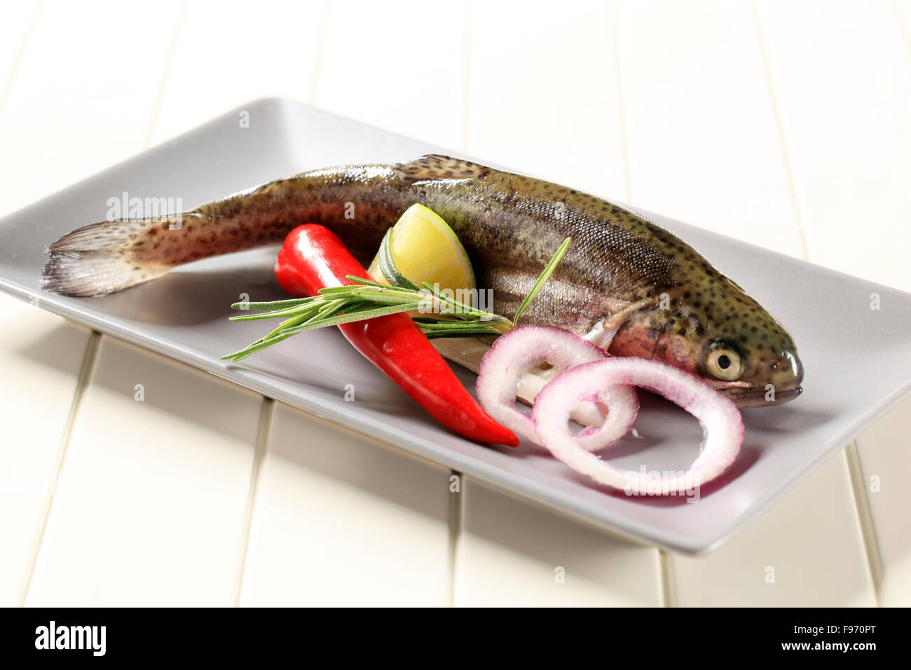 Fresh trout and other ingredients on a plate Stock Photo