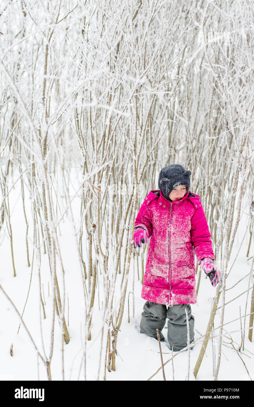Young Girl Walking Through Snowy Winter Forest WIth Pink Coat Stock ...