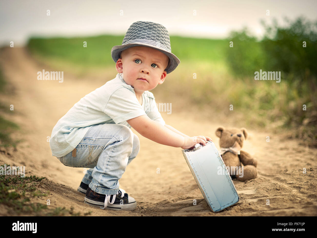 Little boy playing with teddy bear on the footpath Stock Photo - Alamy