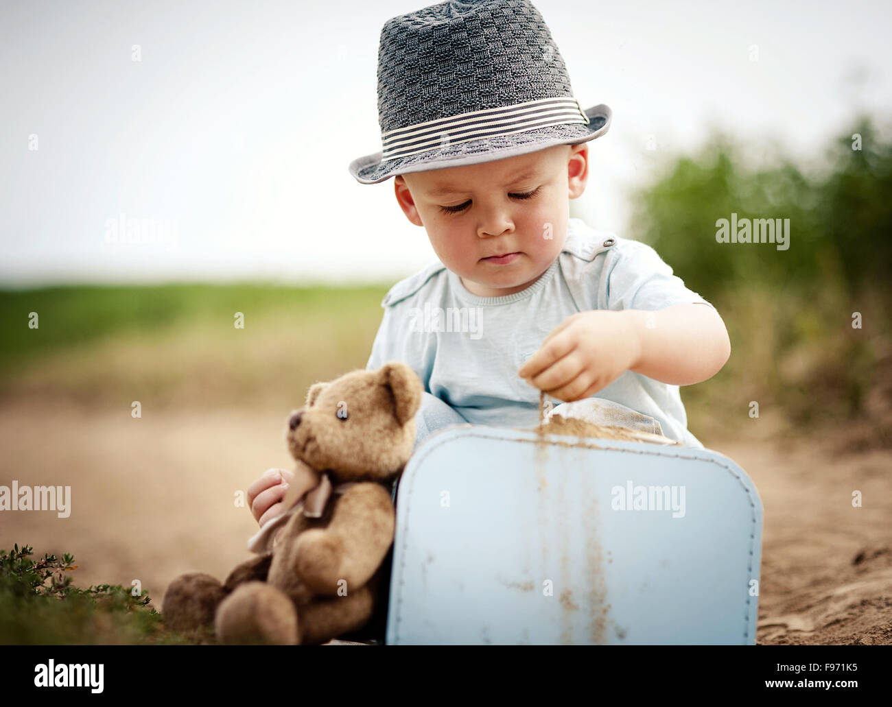 Little boy playing with teddy bear on the footpath Stock Photo - Alamy