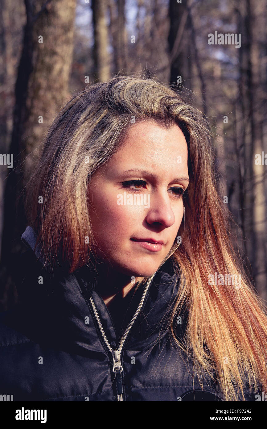 Serious young woman portrait looking foward in the forest Stock Photo
