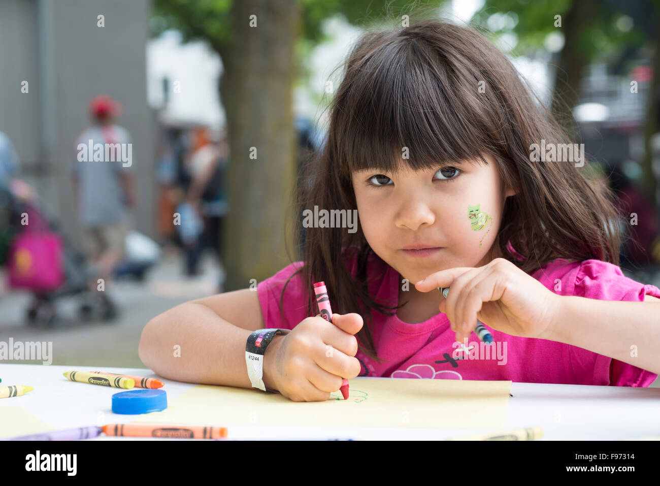 Young girl colouring at the Vancouver International Children's Festival. Granville Island, Vancouver, British Columbia, Canada Stock Photo