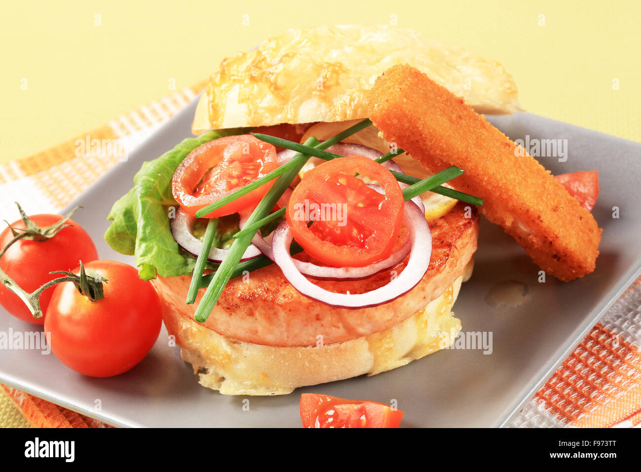 Salmon burger and fish stick with vegetable garnish Stock Photo Alamy