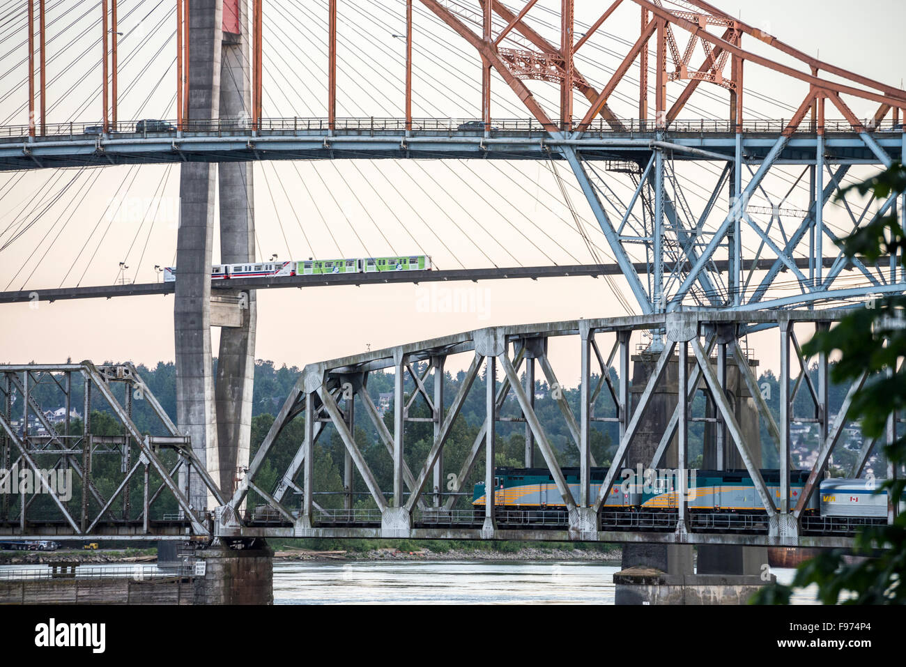 Pasenger train going over a bridge, Vancouver Skytrain going over the Skytrain bridge, and cars going over the Patullo Bridge Stock Photo