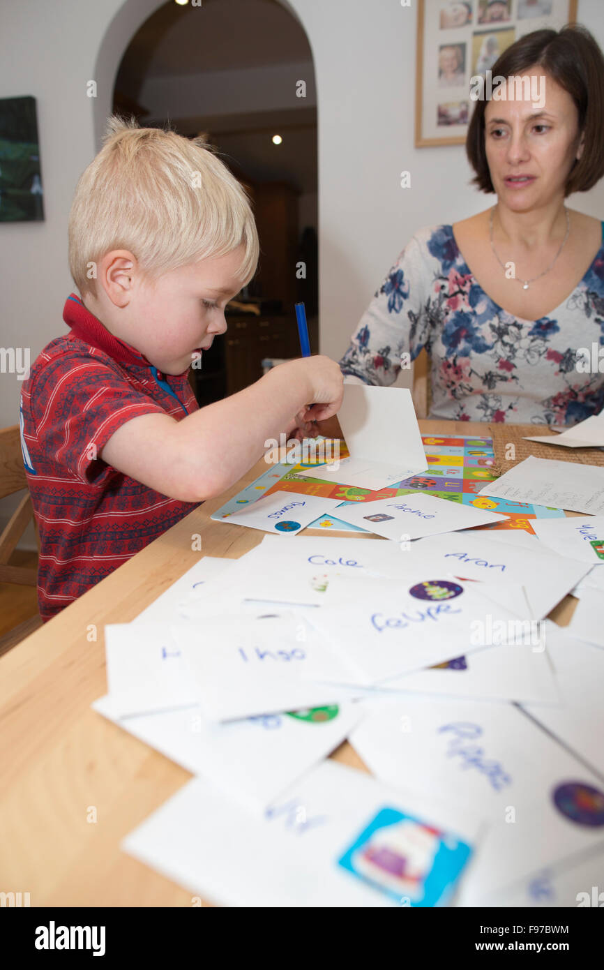 Five year old boy writing his Christmas cards to classmates and school friends, UK Stock Photo