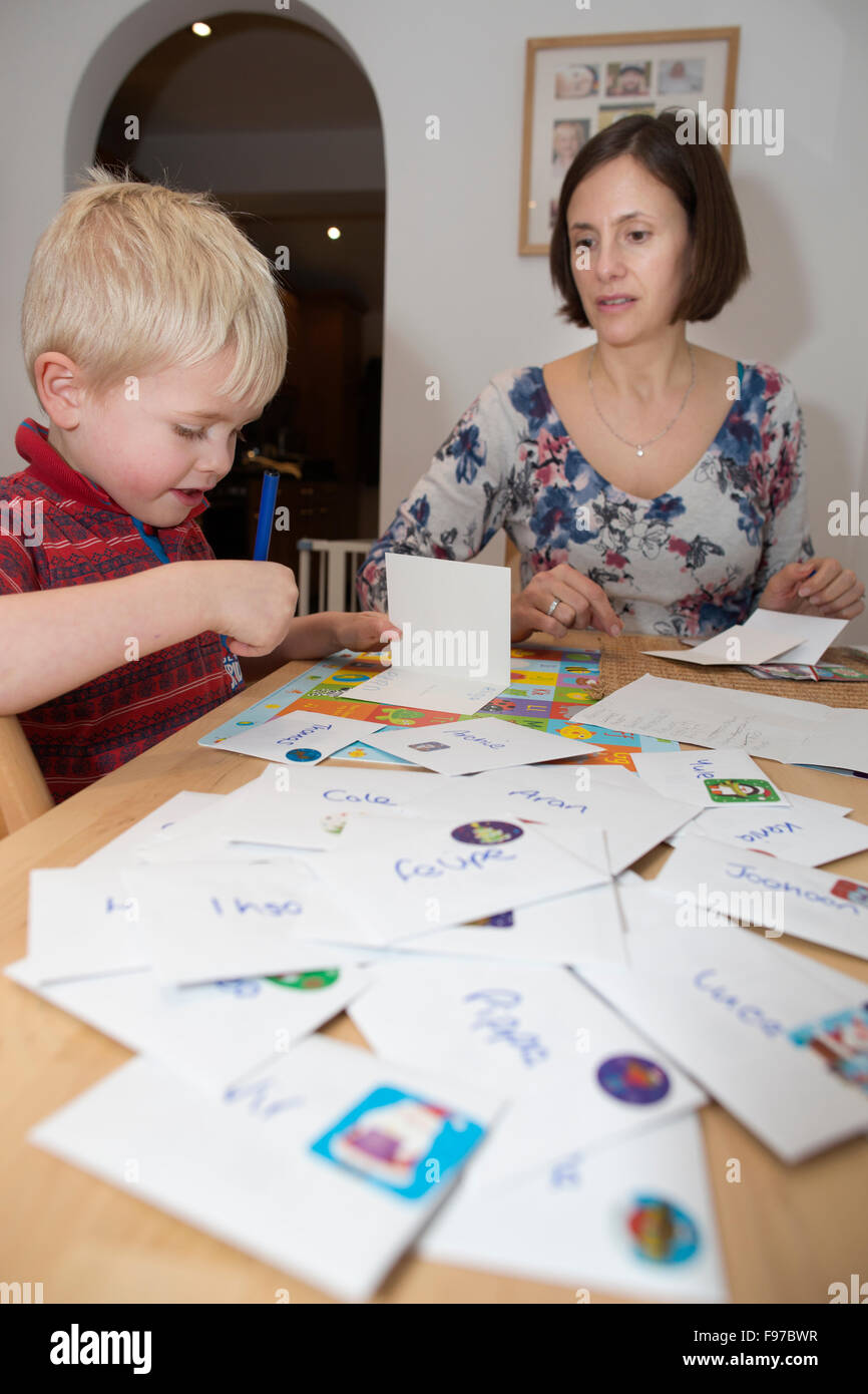 Five year old boy writing his Christmas cards to classmates and school friends, UK Stock Photo