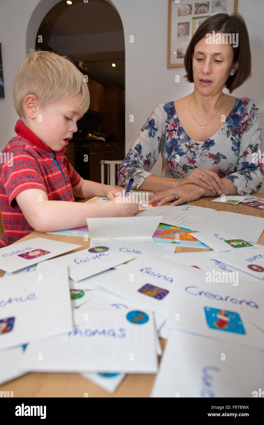 Five year old boy writing his Christmas cards to classmates and school friends, UK Stock Photo