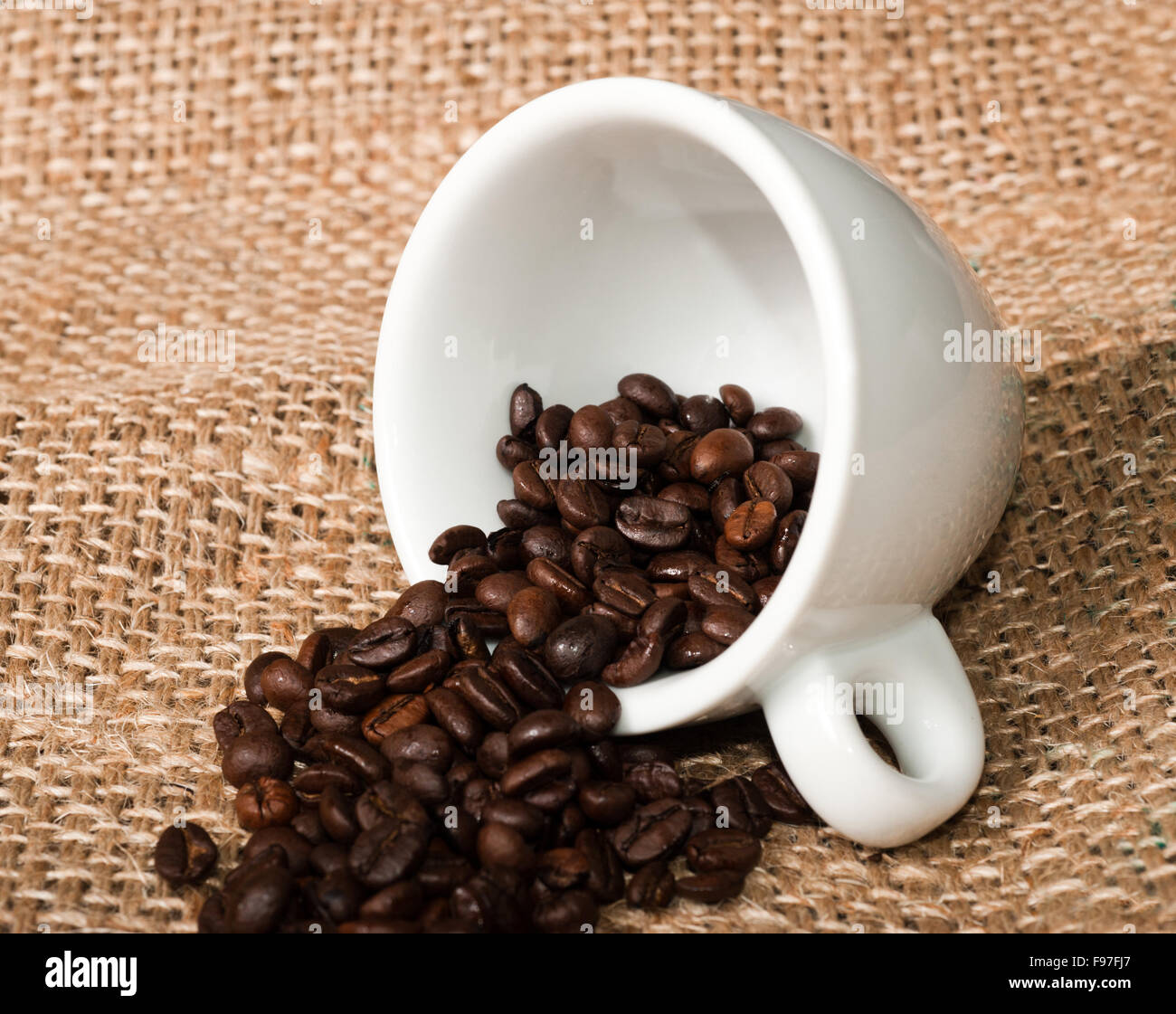 Coffee cup and beans on jute background Stock Photo