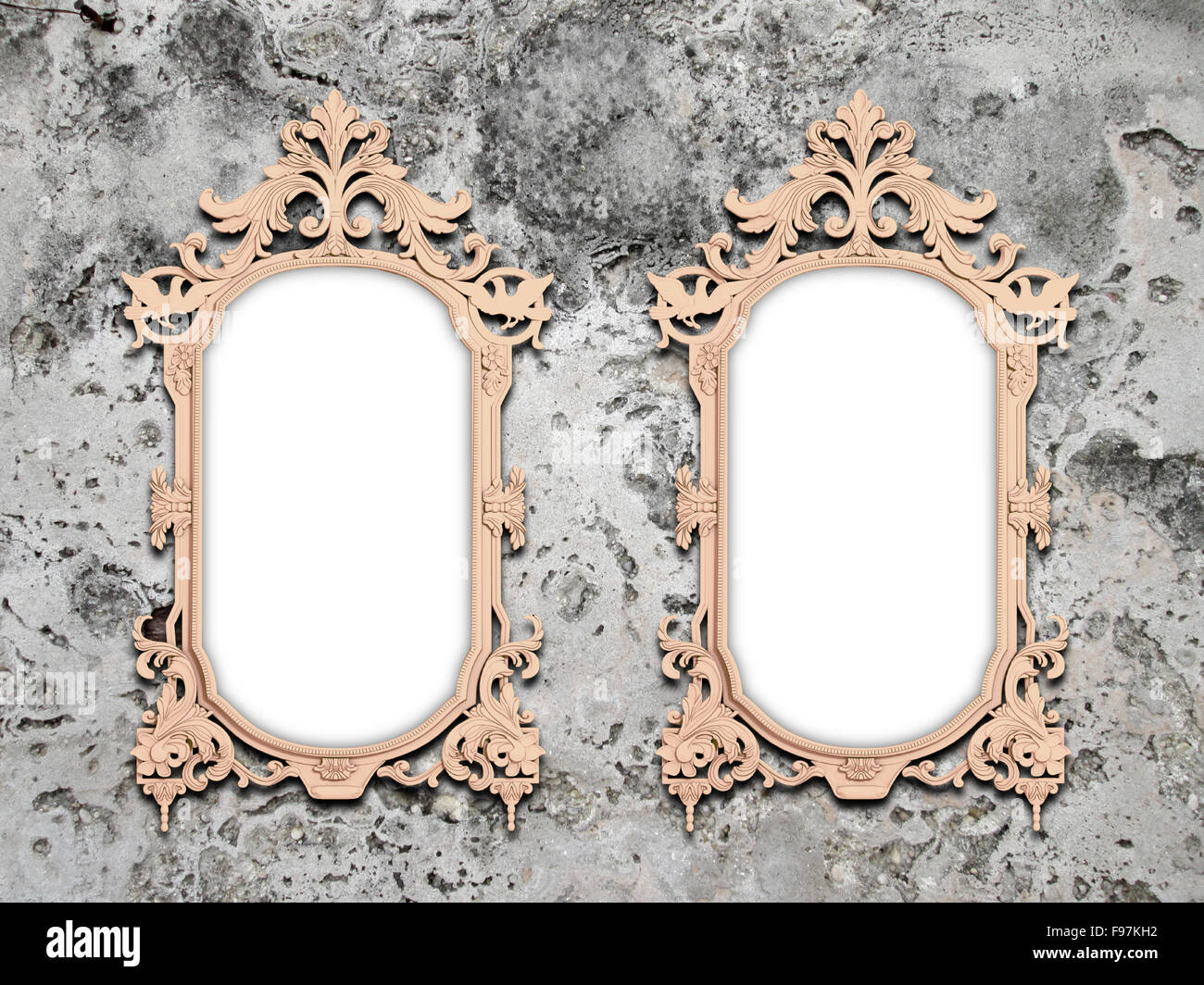 Closeup of two pink baroque frames on grey stained concrete wall