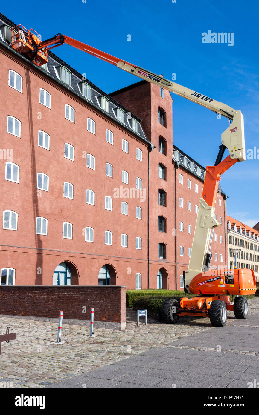 Workers replacing windows at height using an articulated boom lift. Stock Photo