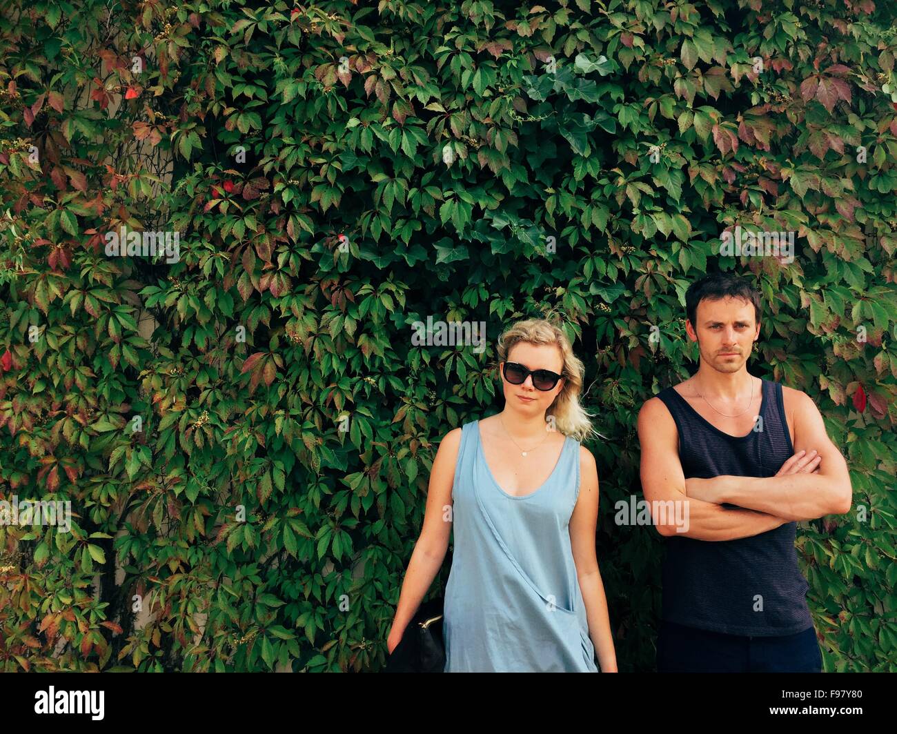 Portrait Of Friend Standing Against Ivy Covered Wall Stock Photo
