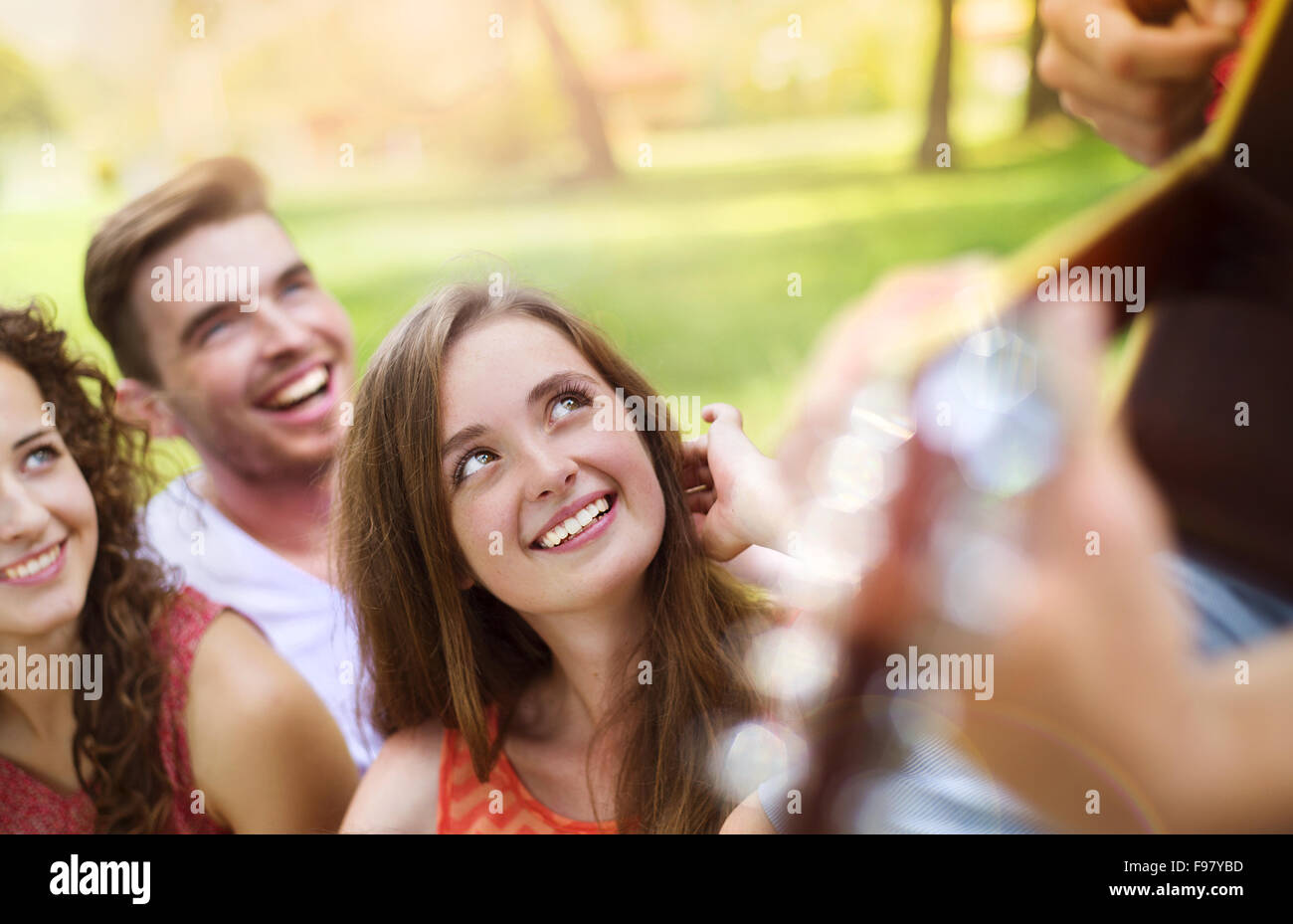 Group of happy friends with guitar having fun outdoor Stock Photo