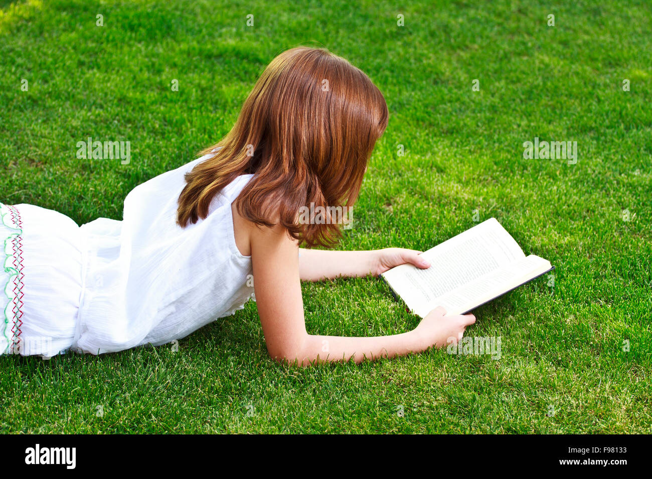 Young beautiful girl reading a book outdoor Stock Photo - Alamy